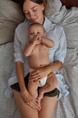 Yorgun bir anne bebeğiyle dinleniyor.