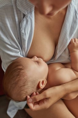 Anne küçük sevimli çocuğu emziriyor ve besliyor.