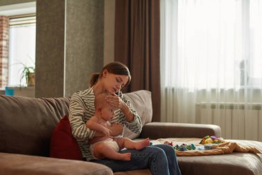Anne telefonda doktoru arıyor. Bebek sağlığı için endişeleniyor.