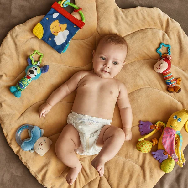 Bebek renkli oyuncaklarla paspas oynuyor