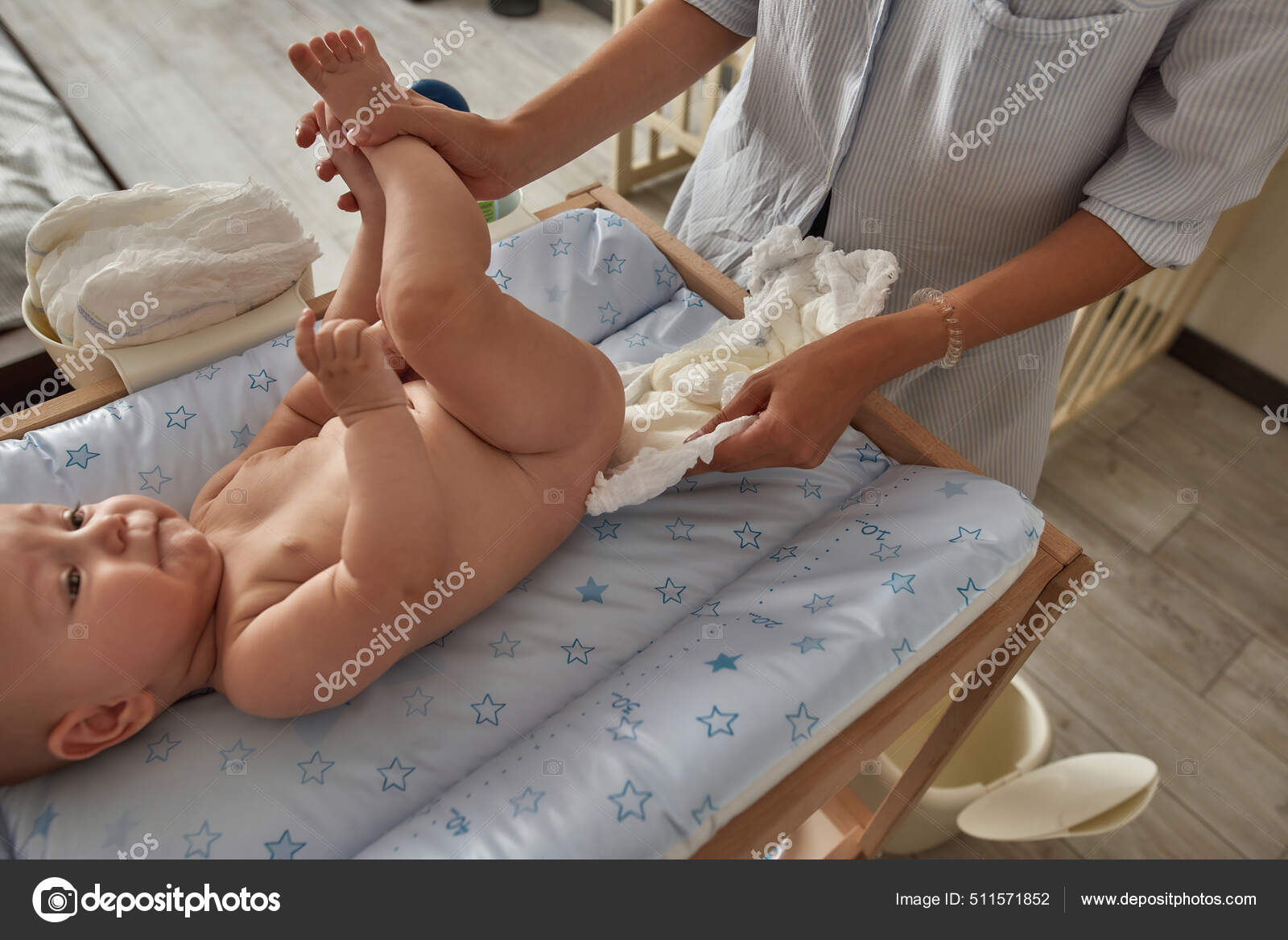 Mère portant une couche fraîche sous le bébé image libre de droit
