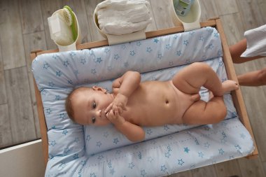 Bebek odasında çıplak bir erkek bebek, üst manzara.