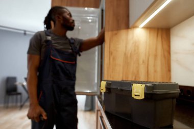 Mutfak yüzeyinde servis araç gereçleri, arka planda tamirci, mavi