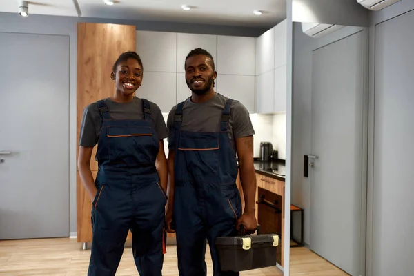 Sonrientes trabajadores multiétnicos del servicio de reparación en el apartamento —  Fotos de Stock
