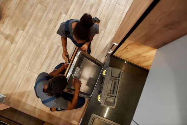 Szerelő, amely bemutatja a tanonc, hogyan kell telepíteni mosogatógép, felső nézet — Stock Fotó