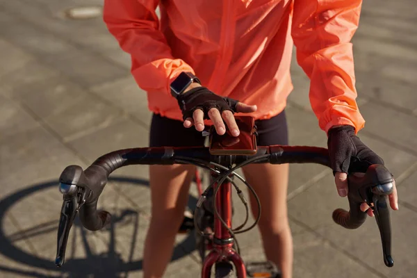 Κοντινό πλάνο του ποδηλάτη γυναίκα χρησιμοποιούν συσκευή κινητής τηλεφωνίας — Φωτογραφία Αρχείου