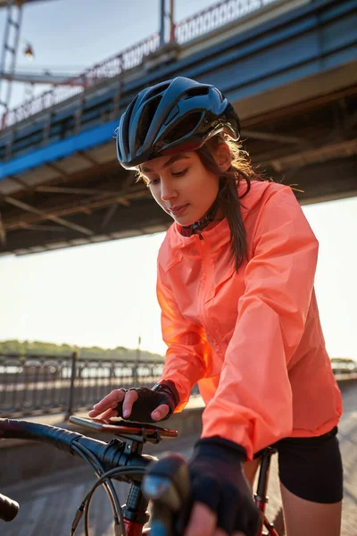 Millennial γυναίκα ποδηλάτης χρησιμοποιούν το διαδίκτυο app στο smartphone — Φωτογραφία Αρχείου
