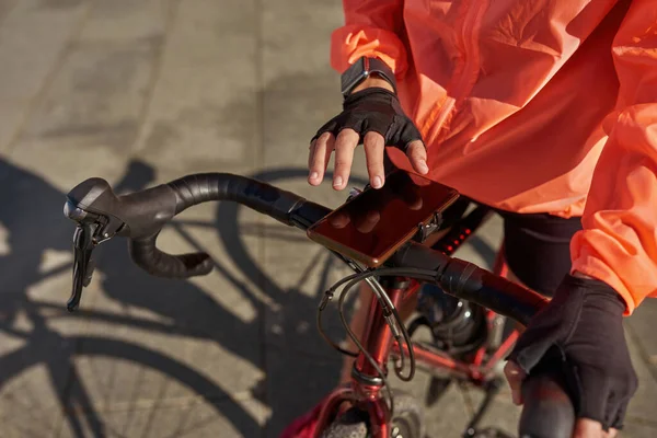 Blisko kobiety rowerzysta używać roweru na telefon komórkowy — Zdjęcie stockowe