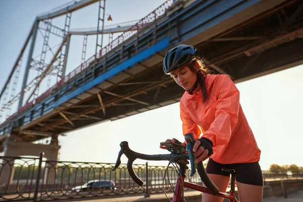 Αθλητική χιλιετή γυναίκα ποδηλάτης χρησιμοποιούν κινητό τηλέφωνο ιππασίας ποδήλατο — Φωτογραφία Αρχείου