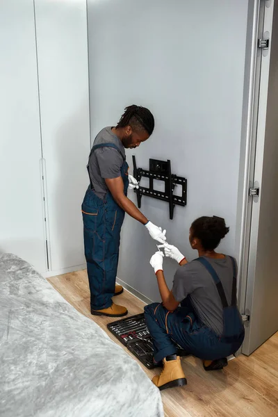 Dos trabajadores de servicio instalan montaje en pared TV — Foto de Stock