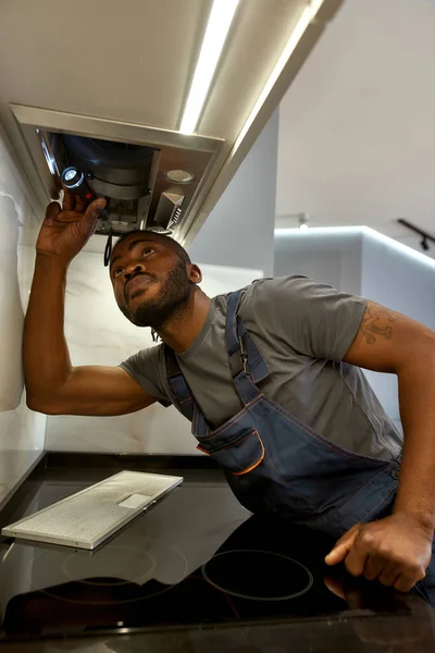 Trabajador joven durante el servicio de reparación de campana de ventilación —  Fotos de Stock