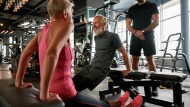 Spor salonunda sıkı çalışırken gülümseyen son sınıf sporcusu.