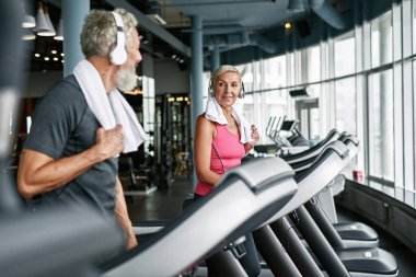 Spor salonundaki koşu bandında mutlu çift