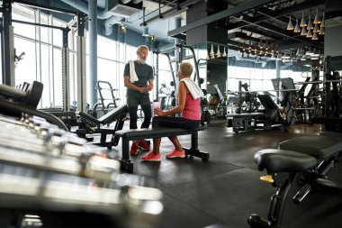 Emeklilikten sonra sağlıklı bir yaşam tarzı, spor yaptıktan sonra birkaç yaşlı insanla modern spor salonu.