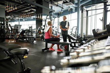 Spor salonundaki iki mutlu son sınıf öğrencisi eğitimden önce konuşuyor.