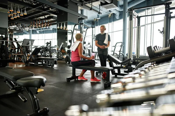 Spor salonundaki iki mutlu son sınıf öğrencisi eğitimden önce konuşuyor.