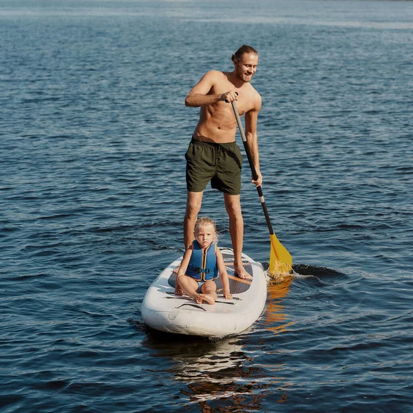 Vater reitet seine Tochter auf Kajak mit Paddel — Stockfoto