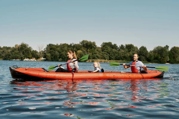 Piękna rodzina pływa na kajaku w jeziorze lub rzece — Zdjęcie stockowe