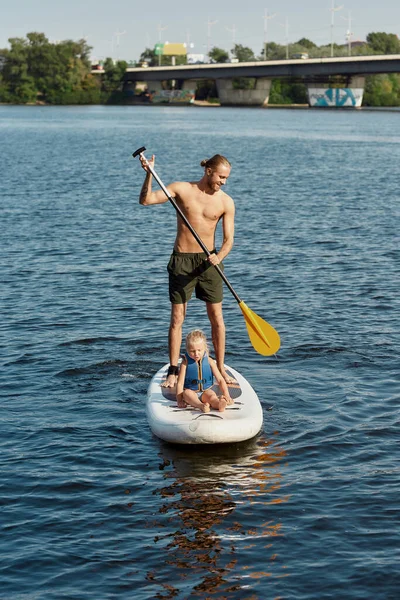 Vater fährt Kind auf Kajak mit Paddel — Stockfoto