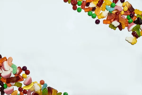 Fond de bonbons gelée colorés à base de jus de fruits, de gélatine et de sucre dans les coins isolés sur fond blanc — Photo