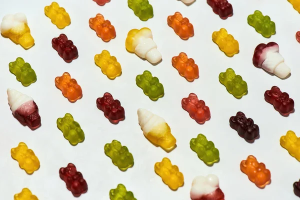 Крупный план красочных мармеладных медведей и мороженого конфеты лежал по диагонали изолированы на белом фоне — стоковое фото