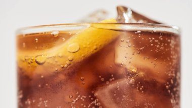 Bir bardak tatlı soda, içinde buz küpleri ve limon olan bir bardak kola.