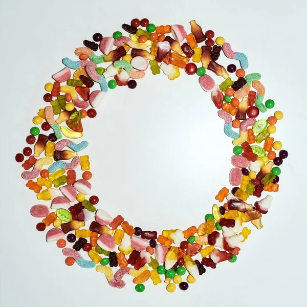 Flatlay de doces coloridos, doces de geleia feitos de suco de frutas, gelatina e açúcar deitado na forma de círculo isolado sobre fundo branco — Fotografia de Stock