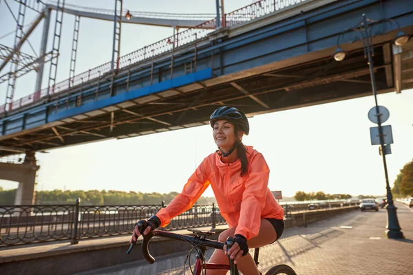 Smiling active 20s girl ride bike outdoors