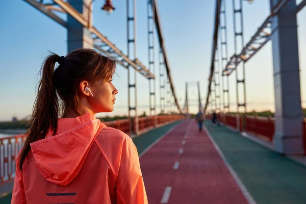 Millennial ταιριάζει γυναίκα τρέχει τρέξιμο έξω ακούγοντας μουσική — Φωτογραφία Αρχείου