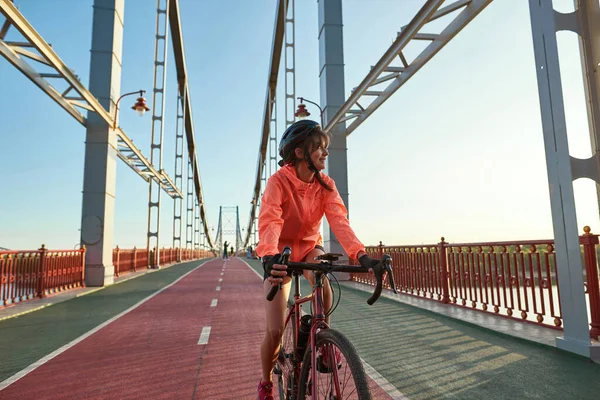 Smiling 20s female cyclist ride bike training