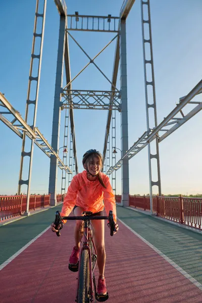 Χαμογελώντας χιλιετή κορίτσι βόλτα ποδήλατο στη γέφυρα της πόλης — Φωτογραφία Αρχείου