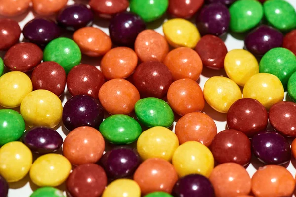 Close up shot of colorful chocolate coated candies on a white background — Stock Photo, Image