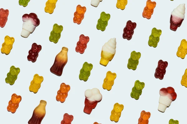Крупный план разнообразных вкусных конфет в форме медведя и мороженого лежащих по диагонали изолированы на белом фоне — стоковое фото