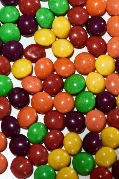Beyaz arka planda renkli çikolata kaplı şekerlemelerin üst görüntüsü — Stok fotoğraf
