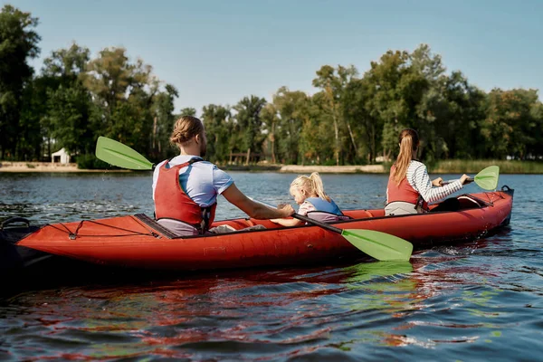 Giovane famiglia galleggiante su kayak con pagaie — Foto Stock