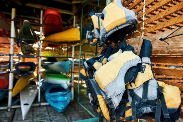 Chalecos salvavidas en perchas y kayaks almacenados — Foto de Stock