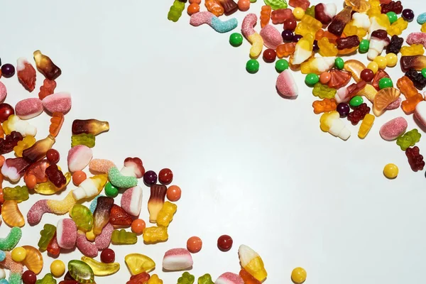 Pile de bonbons colorés à base de jus de fruits, de gélatine et de sucre dans les coins isolés sur fond blanc — Photo