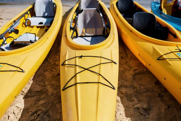 Collection of kayaks in row on beach near water — Stock Photo, Image