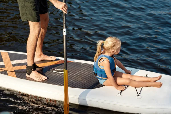 Far rider sin lilla flicka på kajak med paddel — Stockfoto