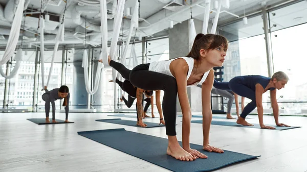 Sportovní mladá žena vlak létat jóga ve studiu — Stock fotografie