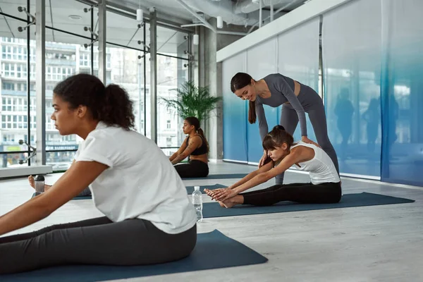 Coach féminin aider les clients à la séance de yoga en studio — Photo