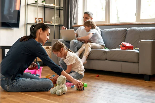 Jovem família caucasiana relaxar em casa com as crianças — Fotografia de Stock