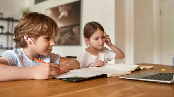 Adolescente crianças pequenas estudar on-line no computador em casa — Fotografia de Stock