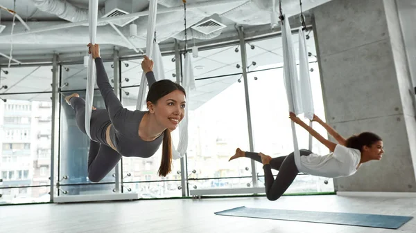 Sorrindo diversas mulheres têm alongamento voar aula de ioga — Fotografia de Stock