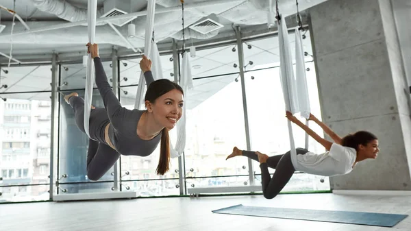 Zâmbind diverse femei au stretching fly yoga clasa — Fotografie, imagine de stoc