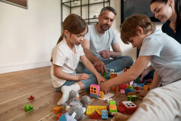 Kinderen hebben plezier spelen speelgoed met liefhebbende ouders — Stockfoto