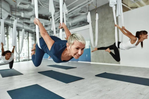 Sorrindo ativo meia-idade mulher prática voar ioga — Fotografia de Stock