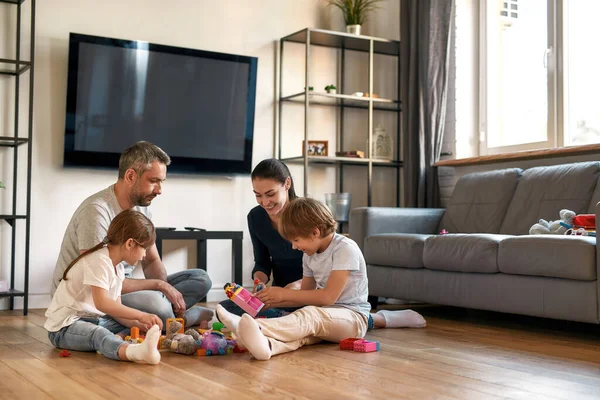 Glückliche Eltern spielen am Wochenende mit Kinderspielzeug — Stockfoto