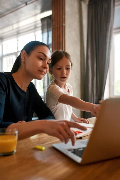Jovem mãe e filha pequena estudar on-line no computador — Fotografia de Stock