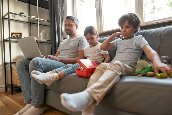 Druk vader werken online op laptop kinderen spelen — Stockfoto